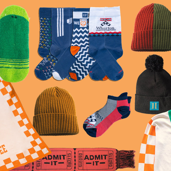 Custom corporate holiday gifts including logo socks, knit beanies, a branded blanket, a knit scarf, and a custom cardigan.